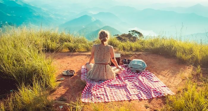 woman sitting on picnic blanket overlooking vista.jpg.optimal