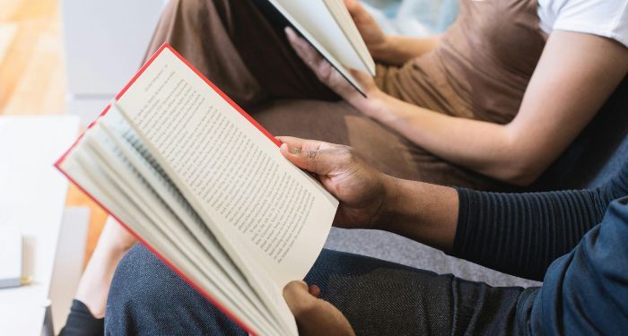 the hands of two people with different skin tones reading books.jpg.optimal