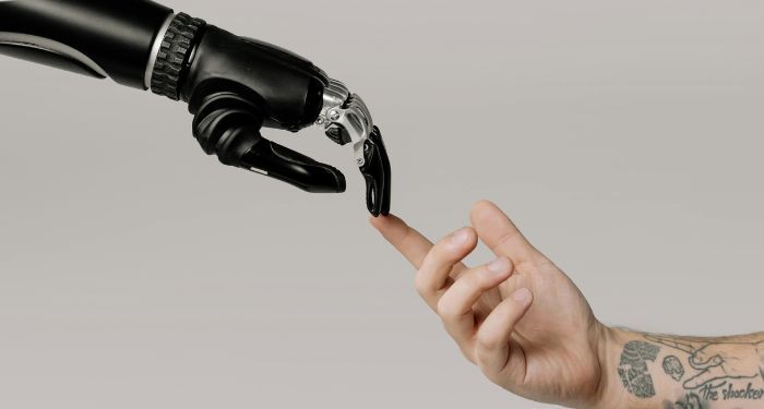 a robot arm touching fingers with a tatted white male arm in the style of the Creation of Adam paint